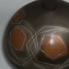Detail of a patinated bronze vase in shiny and mat finish, inlaid with geometric motifs in silver and red bronze, by Kanamori Eiichi (1908-2001)