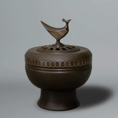 Brûle encens en bronze patiné, décoré de cercles entrelacés, le couvercle percé surmonté d’un oiseau stylisé par Takahashi Kaishu