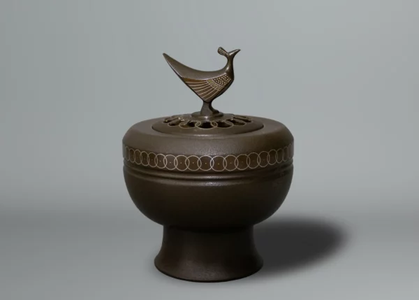 Brûle encens en bronze patiné, décoré de cercles entrelacés, le couvercle percé surmonté d’un oiseau stylisé par Takahashi Kaishu